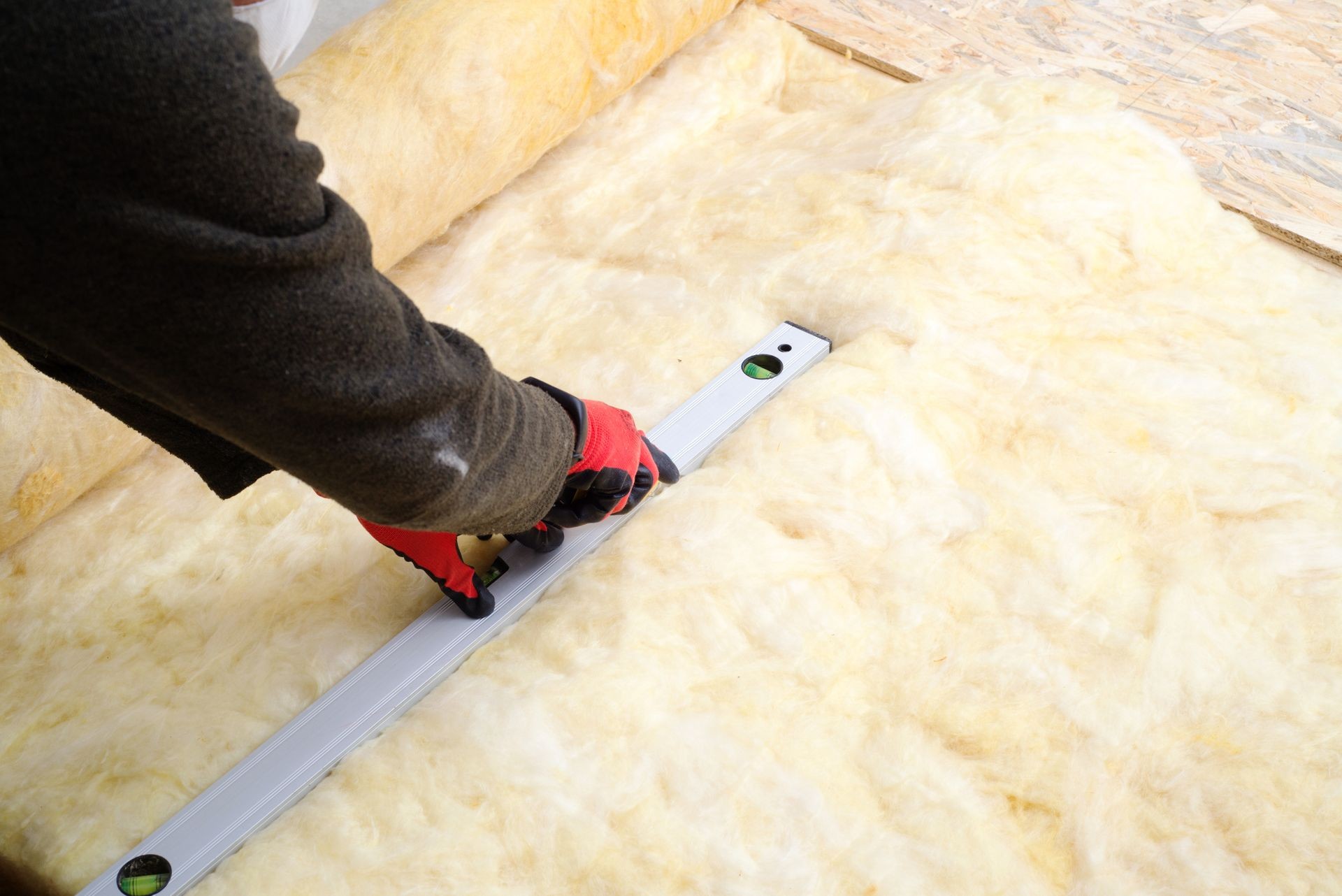 Work composed of mineral wool insulation in the floor, floor heating insulation , warm house, eco-friendly insulation, a builder at work