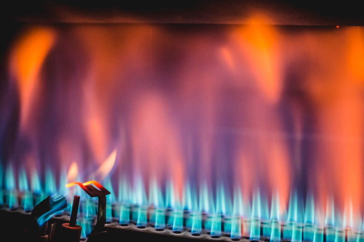 View of flame tongues burning in blaze and warming roaster cylinder for coffee roasting