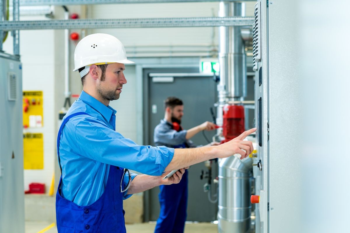 two worker in blue work clothes in industrial plant